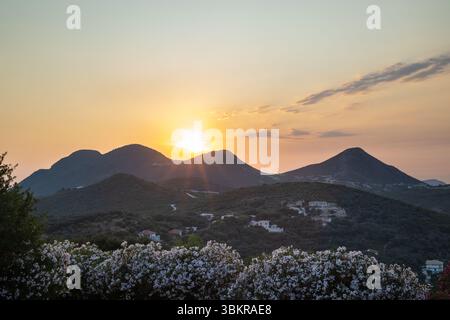 Tramonto dorato sulle lussureggianti Green Hills con villaggi lontani Foto Stock