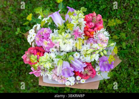 Bouquet di fiori avvolti di fiori primaverili misti. Splendida disposizione di fiori freschi color pastello. Bouquet di compleanno con draghi di dentini, matthiola Foto Stock