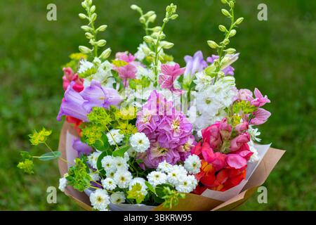 Bouquet di fiori avvolti di fiori primaverili misti. Splendida disposizione di fiori freschi color pastello. Bouquet di compleanno con draghi di dentini, matthiola Foto Stock