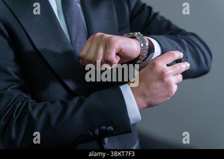 Orologio di controllo delle mani dello sposo – dettaglio matrimonio da primo piano Foto Stock