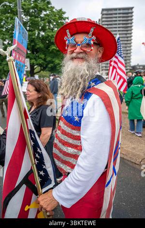 Un uomo vestito da zio Sam porta la bandiera alla Philadelphia No Kings March Foto Stock