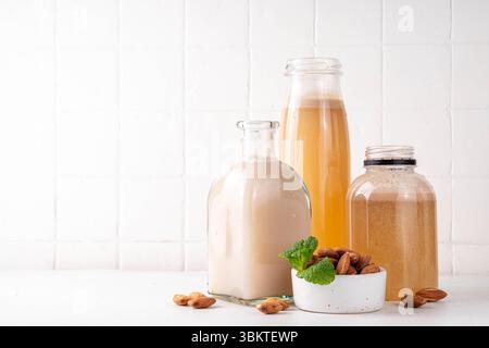 Sciroppo d'Orgeat alle mandorle fatto in casa in diverse bottiglie, mandorle, acqua, zucchero e sciroppo d'acqua al fiore d'arancia per preparare cocktail dolci Foto Stock