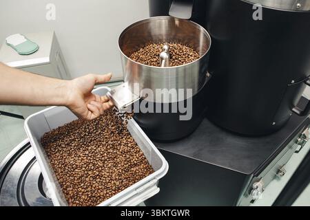 Macchina per la torrefazione del caffè che distribuisce fagioli appena tostati Foto Stock
