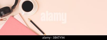 Banner con copybook, tazza di caffè e cuffie su sfondo beige. Foto Stock