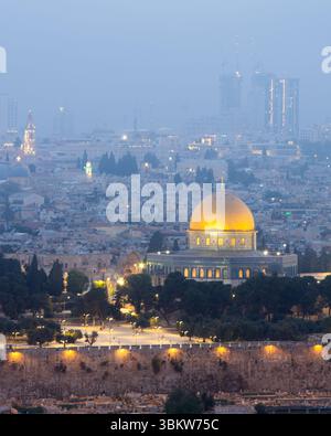 La città vecchia di Gerusalemme, l'iconica Cupola della roccia in una serata nebbiosa dopo il tramonto, visto dalla cima del Monte degli Ulivi Foto Stock