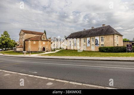 Proprio accanto al Battistero di Saint-Jean (Baptistère Saint-Jean, Battistero di San Giovanni) in Rue Jean-Jaurès a Poitiers, Nouvelle-Aquitaine, Francia, si trova il Musée Sainte-Croix (Museo della Santa Croce), il più grande museo della città. A destra si erge un lungo edificio con un tetto a padiglione e grandi striscioni sulla facciata, con un cartello indicatore del museo davanti. A sinistra si trova il battistero con i suoi tetti di tegole rosse. La strada attraversa l'antiprincipale. Il museo ha aperto nel 1974 sul sito dell'ex abbazia Sainte-Croix. Ospita ampie mostre permanenti sull'archeologia, l'arte e l'hist Foto Stock