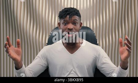Cyber-uomo afroamericano stupito sorpreso dicendo Wow reazione sorprendente guardare la telecamera meraviglia buone notizie in studio futurismo bianco indoor videogamer maschile Foto Stock