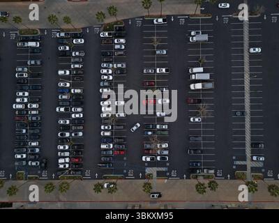 Una varietà di autovetture e camion sono mostrati in un parcheggio da una vista dall'alto durante il giorno. Foto Stock