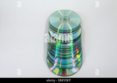 Primo piano di una pila di Compact Disc multicolore caduti su sfondo bianco. Foto Stock