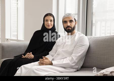 Giovane coppia sposata di etnia araba seduta sul divano Foto Stock