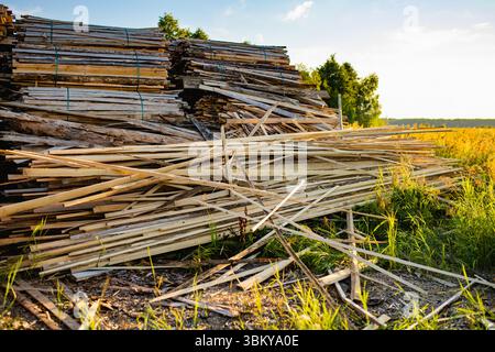 Pile di strisce di legno ruvide e irregolari e piatte ricoperte di corteccia, probabili scarti di legno o rottami di fresatura o carpenteria. Foto Stock