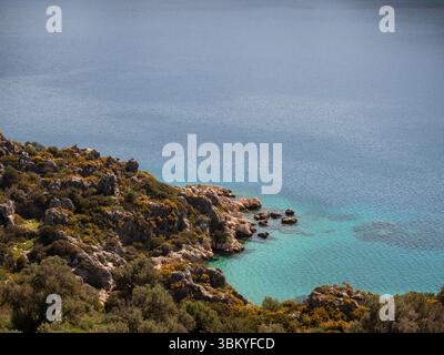 Una vista panoramica di una costa rocciosa che incontra le acque turchesi del mare, mostrando la bellezza naturale del paesaggio. Foto Stock