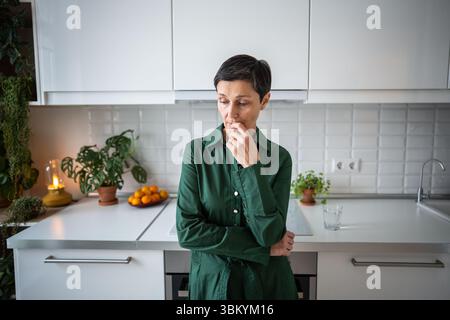 Donna preoccupata e depressa profondamente nei pensieri, contemplazione nella malinconia e angoscia solitudine a casa Foto Stock