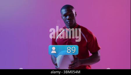Atleta che regge il calcio in maglia rossa all'interno dello studio, con rivestimento blu che mostra l'icona dell'utente e 89 Foto Stock