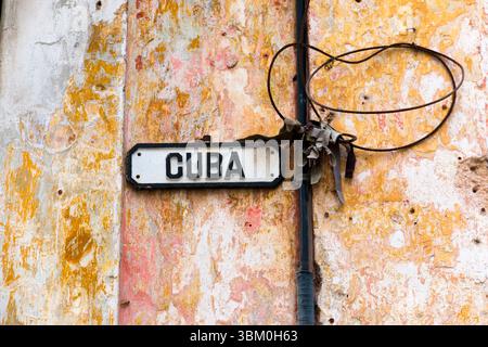 Cuba, l'Avana. Stucco, edificio in legno, blu e giallo, marrone, vernice peeling. Segnale di via Cuba. Foto Stock