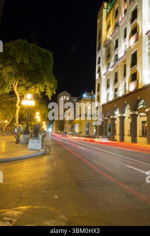 Cuba, l'Avana. Strada di notte con sentieri leggeri per auto. Foto Stock