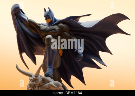 Batman si erge dinamicamente su un gargoyle scuro. Ripresa in studio. Foto Stock