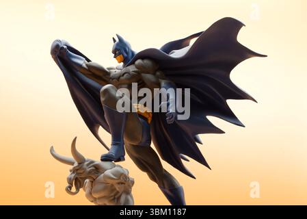 Batman si erge dinamicamente su un gargoyle scuro. Ripresa in studio. Foto Stock
