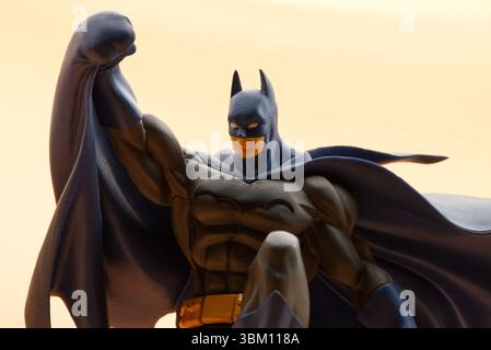 Batman si erge dinamicamente su un gargoyle scuro. Ripresa in studio. Foto Stock