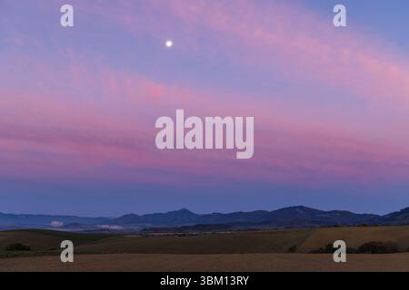 Wonderful landscape at sunset with moon, colorful sky, fields and mountains in Slovakia Foto Stock
