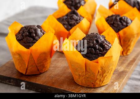 Muffin al cioccolato fatti in casa su una tavola di legno, vista laterale. Foto Stock
