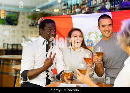 Amici felici che celebrano la vittoria della squadra peruviana nel bar della birra Foto Stock