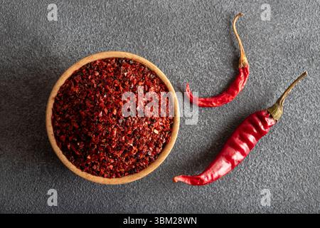 Peperoncino rosso. Peperoncini rossi in un recipiente di legno su sfondo nero. Peperoncini secchi Foto Stock