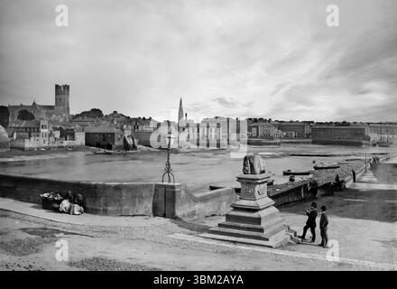 Una fotografia della fine del XIX secolo di due primi turisti che osservano la Treaty Stone situata sul Thomond Bridge, accanto al fiume Shannon mentre scorre attraverso Limerick City. Il trattato di Limerick, fu firmato il 3 ottobre 1691 dopo la guerra tra Guglielmo III d'Inghilterra e suo suocero re Giacomo II e fu notoriamente firmato sulla famigerata pietra che gli dava grande importanza. Foto Stock