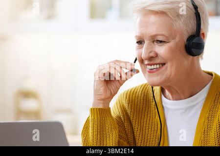 Felice vecchia donna che usa il laptop, che ha una videoconferenza Foto Stock