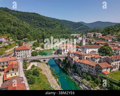 Vista aerea con drone di una pittoresca e idilliaca cittadina medievale Kanal ob Soči. Ponte di pietra sul fiume color smeraldo. Valle di Soča, Slovenia Foto Stock