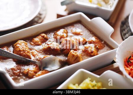 Polpette in salsa di pomodoro. Piatto cotto in ceramica. Cena preparata in casa. Cibo caldo e confortevole. Cucina rustica su tavolo di legno. Foto Stock