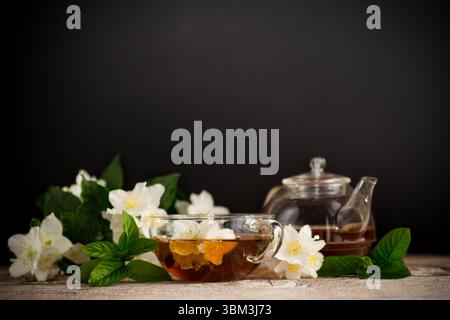 Tazza con tè al gelsomino su sfondo nero. Foto Stock