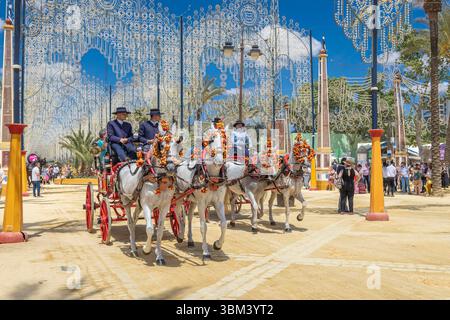 Jerez de la Frontera, Cadice, Andalusia, Spagna. Carrozze trainate da cavalli in processione alla Fiera del Cavallo di Jerez, nota come Feria del Caballo. (Editori Foto Stock