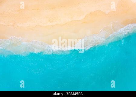 Splendida spiaggia tropicale aerea con mare turchese e sabbia soffice, onde calme e tranquille, rilassante paesaggio estivo, tranquillo sfondo naturale sul mare Foto Stock