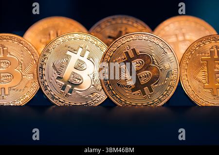 Primo piano astratto di monete d'oro Bitcoin, riflessi leggeri, concetto di criptovaluta, background finanziario digitale, tecnologia di investimento finanziario Foto Stock