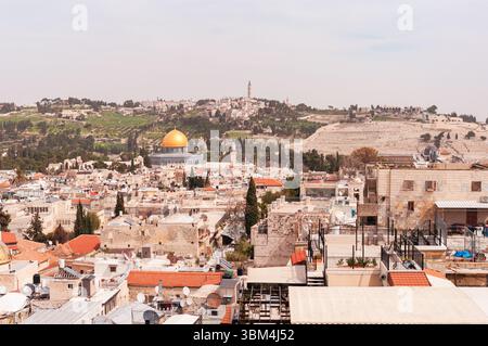 Una vista della città di Gerusalemme con una grande cupola sulla sommità di un edificio. La città è piena di edifici e persone Foto Stock