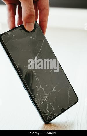 Schermo del cellulare rotto dopo essere caduto sul pavimento Foto Stock