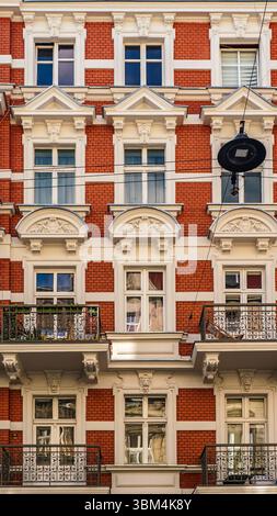 Storica fila di colorati edifici europei che mostrano dettagli architettonici ornati, tra cui balconi in ferro battuto e facciate decorative, in un pict Foto Stock