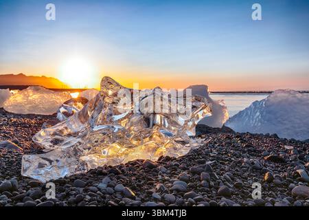 Pezzi Ramarkable dell'iceberg brillano sulla famosa Diamond Beach alla laguna di Jokulsarlon durante il tramonto. Ubicazione : Jokulsarlon Lagoon, Diamond Beach, V Foto Stock
