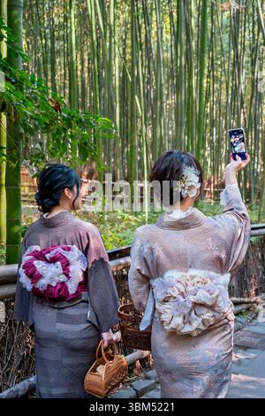 Donne giapponesi in kimono che fanno un selfie, Sagano Bamboo Forest, Arashiyama, Kyoto, Giappone. (Solo per uso editoriale) Foto Stock