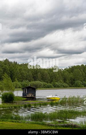 Lago nell'Estonia meridionale, Värska, barca gialla sulla riva in acqua Foto Stock