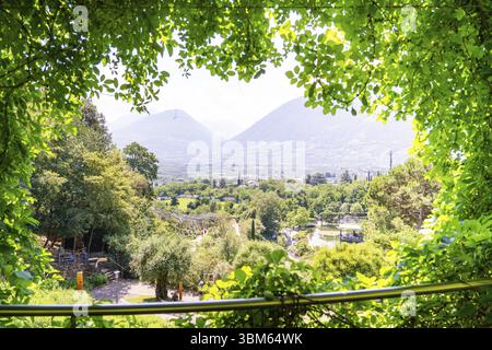 Vista panoramica su una valle con alberi e montagne sullo sfondo, Giardini Botanici, Giardini del Castello di Trauttmansdorff, Merano, Tyr meridionale Foto Stock