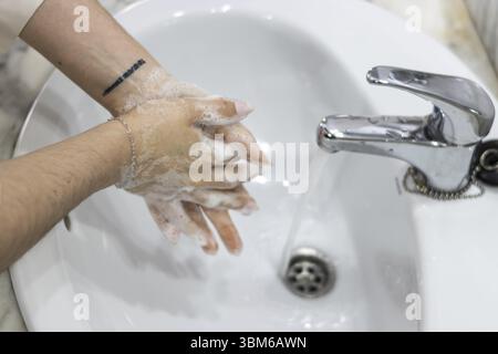 Mani igieniche. Una donna irriconoscibile che si lava le mani in bagno Foto Stock