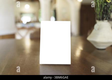 Modello del menu vuoto per la promozione di marketing testuale. Cornice del menu mock-up in piedi su un tavolo di legno nello spazio ristorante per il testo Foto Stock