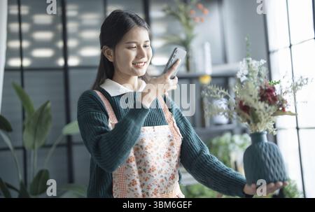Felice fiorista asiatica Startup piccola impresa PMI di successo in negozio di fiori Foto Stock