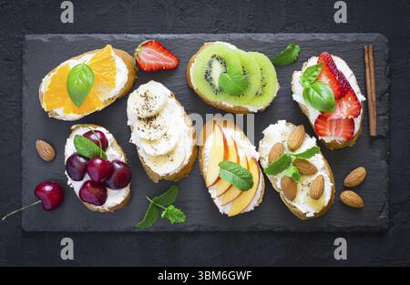 Estate assortiti snack dolci. La bruschetta o panini con frutti e bacche. Vista superiore Foto Stock