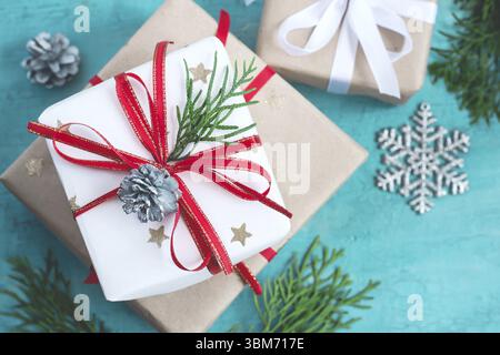 Diverse scatole di Natale di doni addobbate a festa su un sfondo turchese, il fuoco selettivo Foto Stock