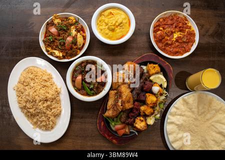 Selezione di salse al curry indiano, carni alla griglia, riso, papavero e lassi di mango Foto Stock