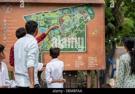 24 luglio 2025, Delhi, Delhi, India: I VISITATORI si fermano a studiare una MAPPA montata in un punto di ritrovo all'interno dello ZOO DI DELHI, uno dei tanti posti sul terreno per aiutare gli ospiti a orientarsi. Mentre i sistemi digitali sono stati adottati per la biglietteria, le mappe murali fisiche rimangono centrali per la navigazione nel parco di 176 acri. Con poche insegne direzionali altrove, questi pannelli fissi spesso diventano punti di affollamento, evidenziando la necessità di un'infrastruttura più intuitiva per i visitatori. (Immagine di credito: © Shubhadeep Mukherjee/ZUMA Press Wire) SOLO PER USO EDITORIALE! Non per USO commerciale! Foto Stock