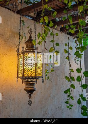 Primo piano di lampade turche tradizionali con motivi geometrici, creando un'atmosfera calda e accogliente in un caffè. Illuminazione interna decorativa: Calda Foto Stock